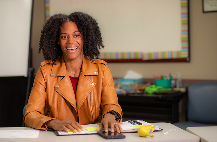 Health Promotion & Wellness degree online alumna Terri Roberts smiles across a conference table in the Foundation for Wellness offices.